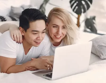 casal na cama assistindo séries e filmes pelo nottebook